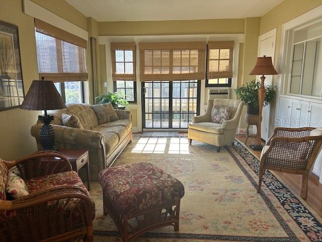 A sunroom features a sofa, armchairs, an ottoman, and large windows with bamboo shades — 130 4TH AVENUE N UNIT 502, ST PETERSBURG, FL