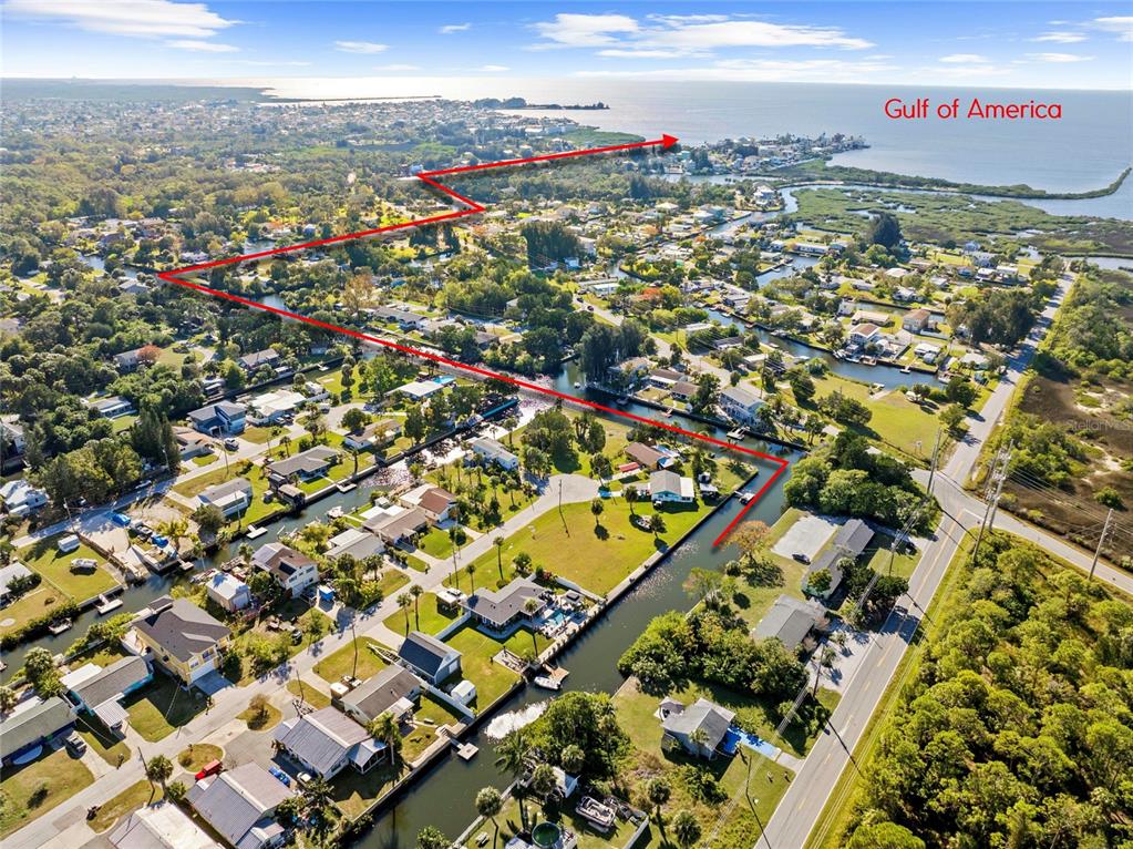 This aerial view shows a residential neighborhood with canals leading toward the Gulf of Mexico — 0 SHEEPSHEAD DRIVE, HUDSON, FL