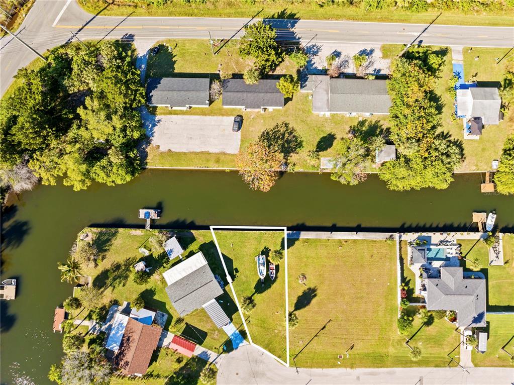 An aerial view shows a waterfront lot with a boat and a small structure — 0 SHEEPSHEAD DRIVE, HUDSON, FL
