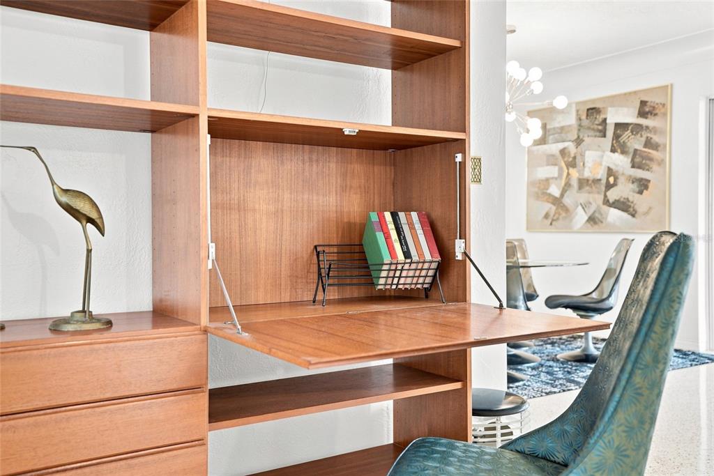 A mid-century modern wooden wall unit features a drop-down desk surface and open shelving — 1842 59TH WAY N, ST PETERSBURG, FL