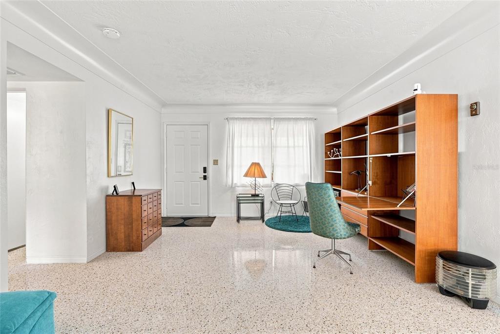 A home office features a large wooden wall unit, a desk chair, and terrazzo flooring — 1842 59TH WAY N, ST PETERSBURG, FL