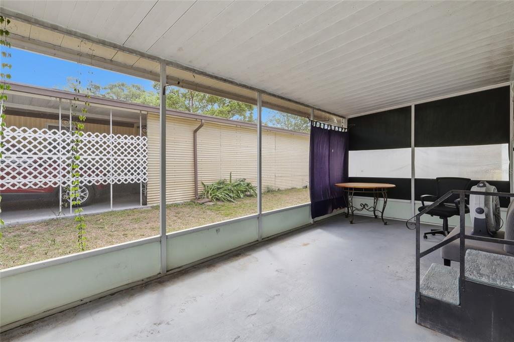 A single-story mobile home with a carport and a screened porch sits on a lawn — 37622 MARCH LANE, ZEPHYRHILLS, FL
