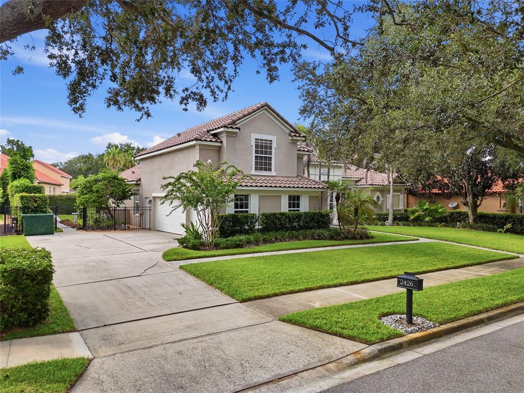 A two-story house with a tile roof, concrete driveway, and manicured lawn — 2426 BAESEL VIEW DRIVE, ORLANDO, FL