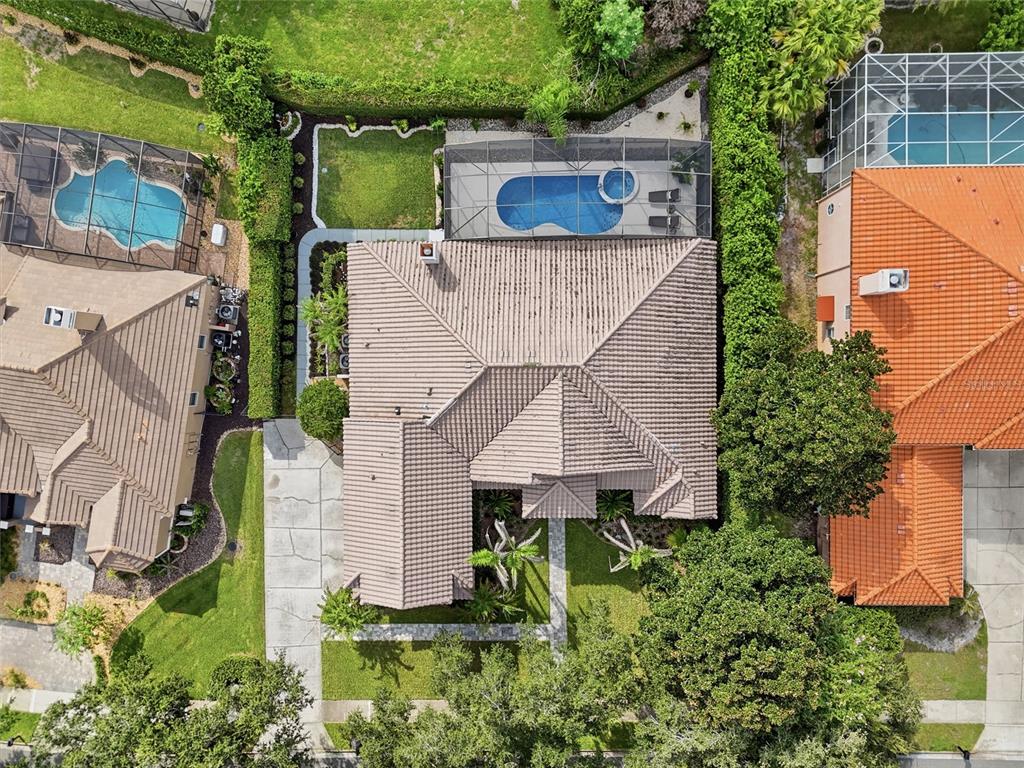 An aerial view shows a house with a tiled roof, pool enclosure, and landscaped yard — 2426 BAESEL VIEW DRIVE, ORLANDO, FL