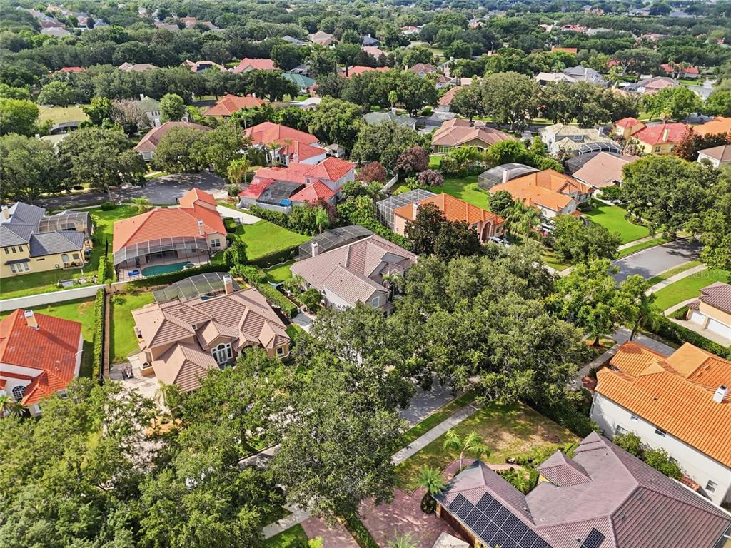 An aerial view shows a suburban neighborhood with multiple houses featuring tile roofs and pools — 2426 BAESEL VIEW DRIVE, ORLANDO, FL