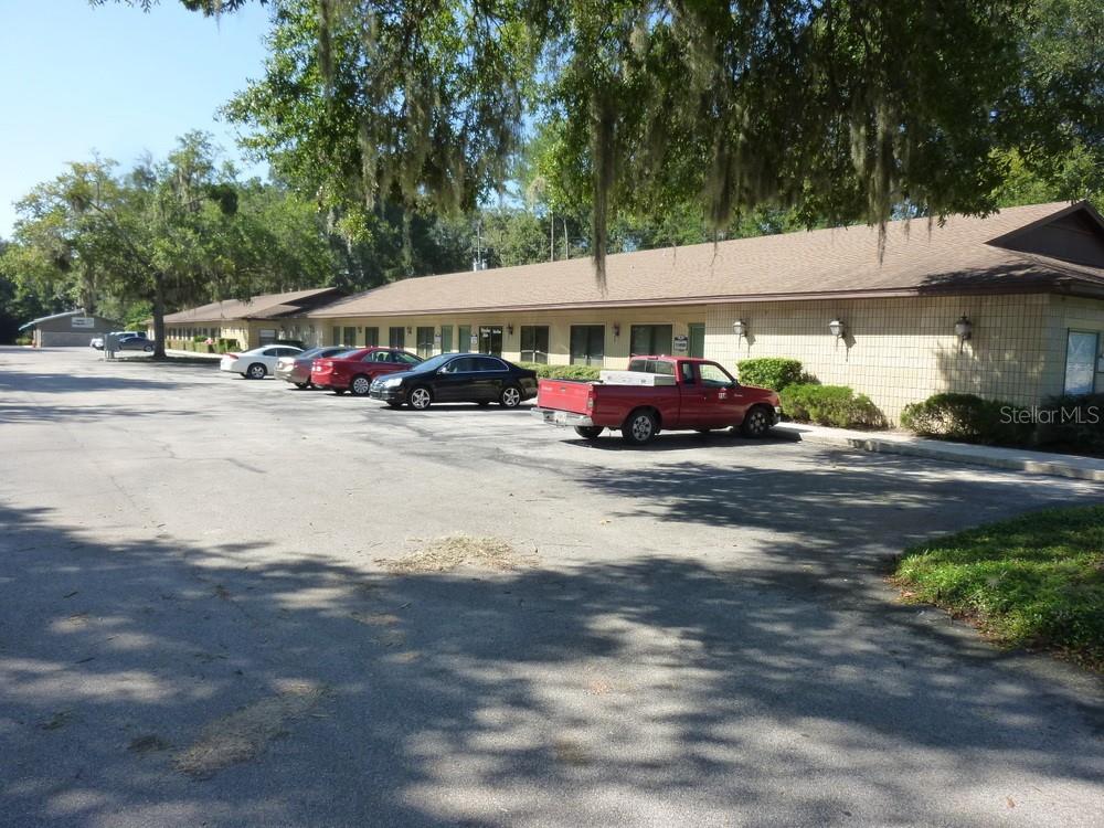 A single-story commercial building with a tan brick facade and a parking lot in front — 4509 NW 23RD AVENUE UNIT 18, GAINESVILLE, FL