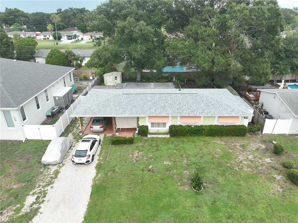 An aerial view shows a single-story house with a light-colored roof and a front driveway — 7485 17TH STREET N, ST PETERSBURG, FL