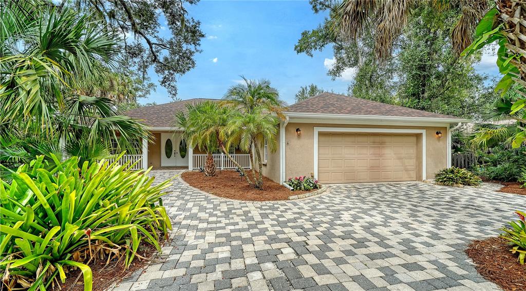 A single-story house with a beige exterior, a two-car garage, and a paved driveway — 2166 SYLVAN LEA DRIVE, SARASOTA, FL