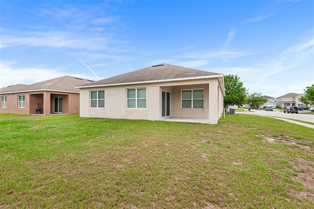 A single-story suburban house with a two-car garage, a front lawn, and a large tree — 4140 SOPHIA BOULEVARD, WINTER HAVEN, FL