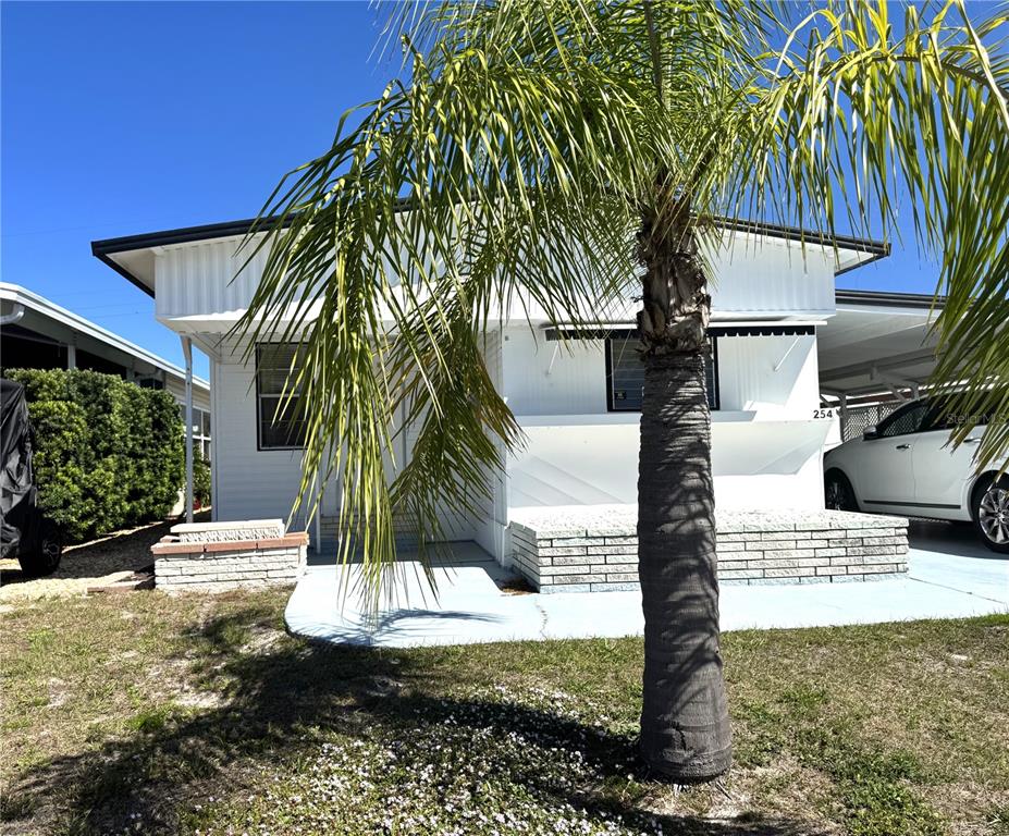 A white mobile home with a palm tree in the front yard — 254 SOUTHWINDS DRIVE, SARASOTA, FL