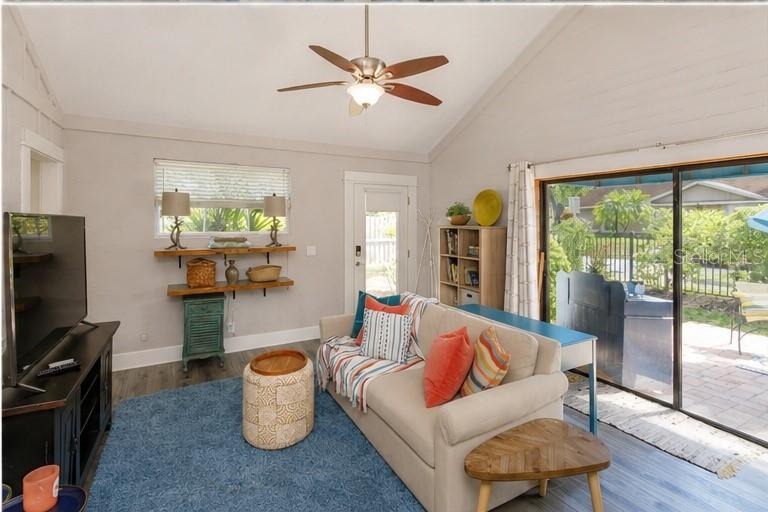 A living room features a beige sofa, blue area rug, ceiling fan, and sliding glass doors — 1802 CHAMBERLIN STREET UNIT 2, ORLANDO, FL
