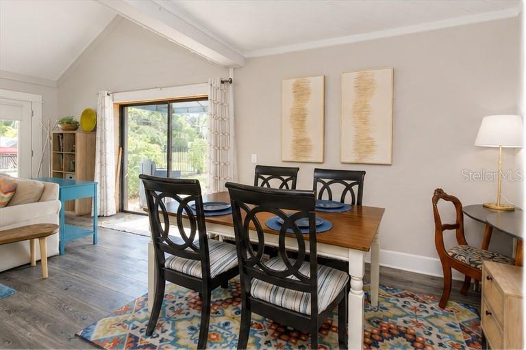 A dining area features a wooden table, four chairs, a patterned rug, and a sliding door — 1802 CHAMBERLIN STREET UNIT 2, ORLANDO, FL