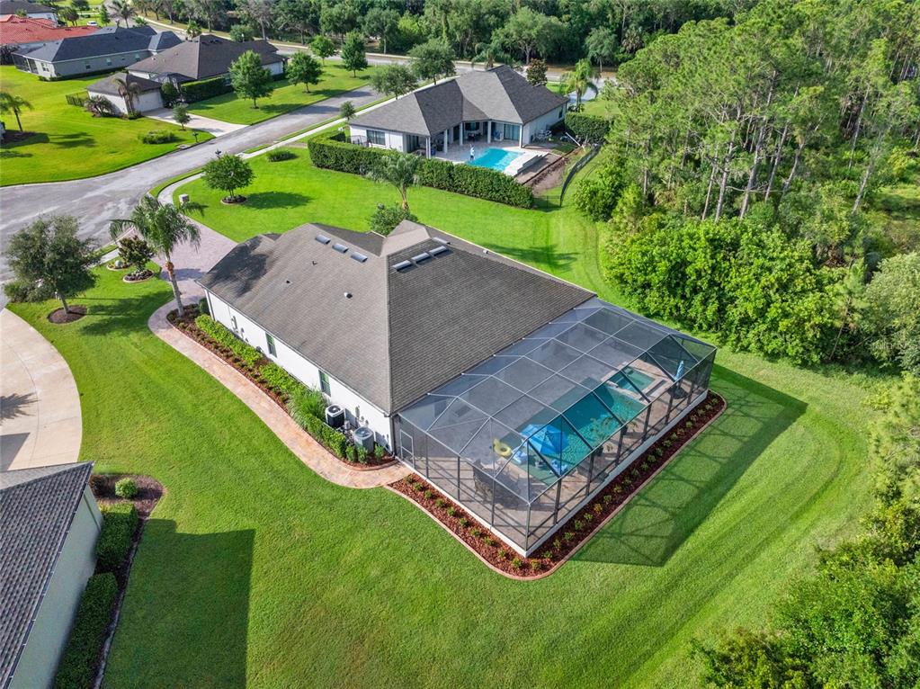 A screened-in patio features a swimming pool with an attached spa and stone decking — 2607 162ND PLACE E, PARRISH, FL