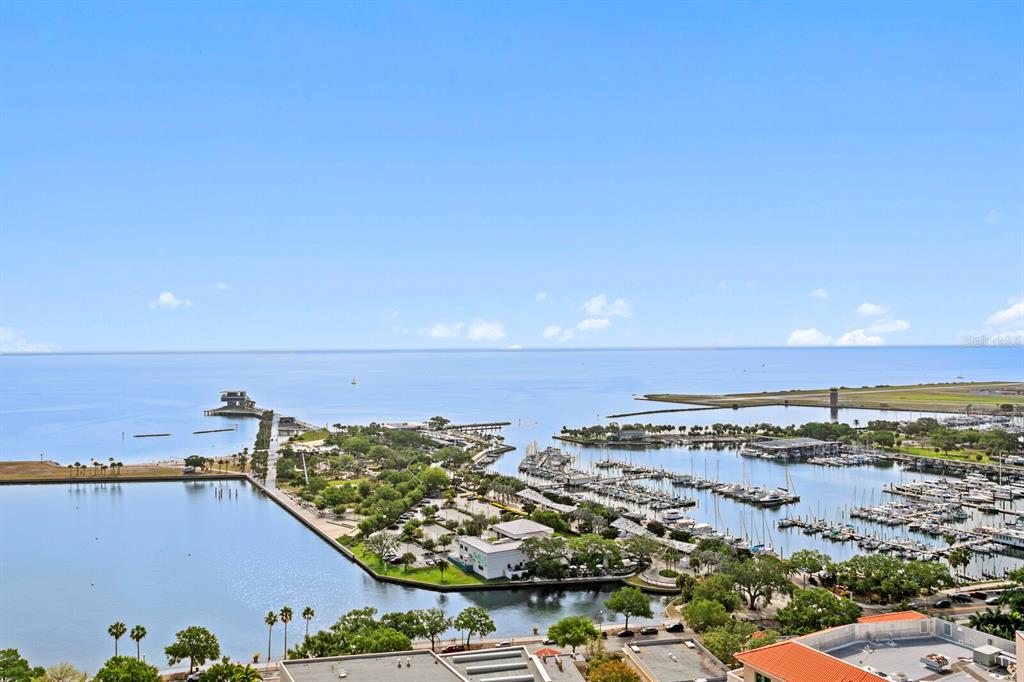 An elevated view of a marina, a pier, and a coastal landscape under a blue sky — 300 BEACH DRIVE NE UNIT 2604, ST PETERSBURG, FL