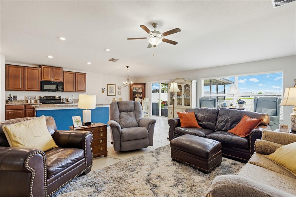 An open-concept living room features a kitchen with brown cabinets and a blue island — 2202 4TH STREET SW, RUSKIN, FL