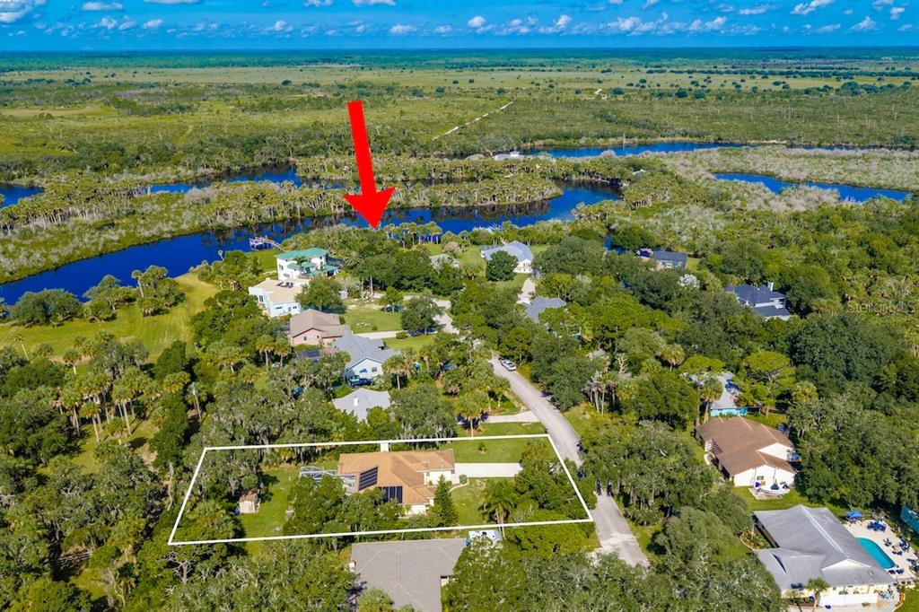 An aerial view shows a residential property with a house outlined in white near water — 821 ROBIN LANE, SEBASTIAN, FL