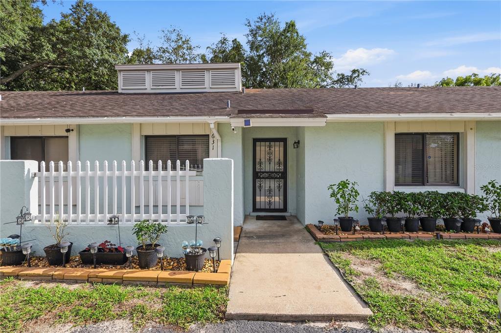 A light green single-story house exterior features a white picket fence and a screen door — 4631 N PINE HILLS ROAD UNIT 110, ORLANDO, FL