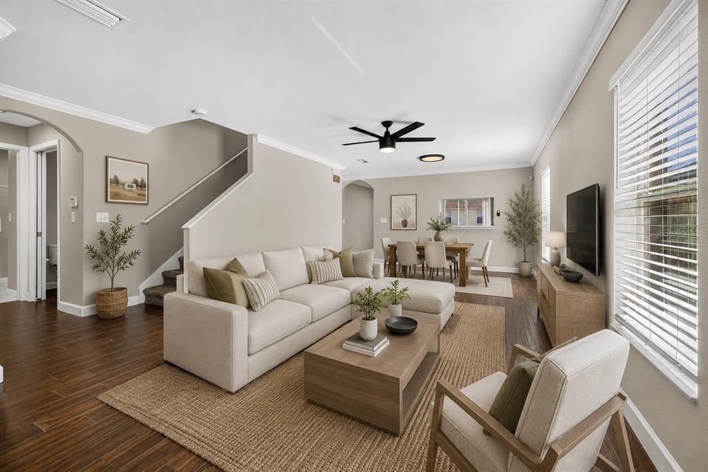 A living room with a sectional sofa, coffee table, and dining area on wood floors — 10629 SHADY PRESERVE DRIVE, RIVERVIEW, FL