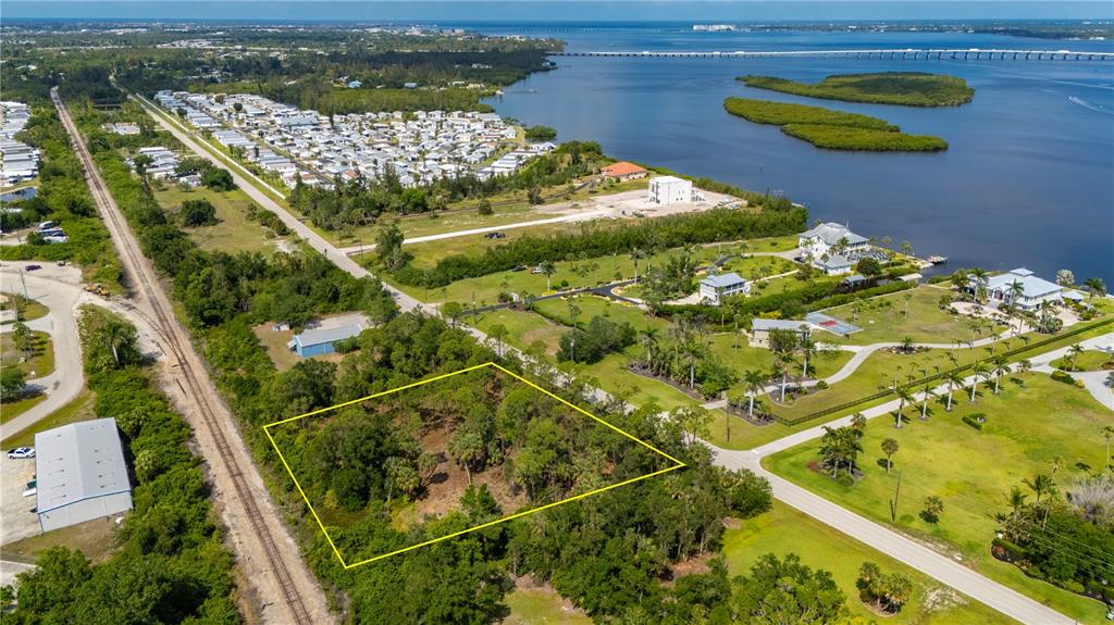 An aerial view shows a rectangular, wooded vacant lot outlined in yellow near a waterway — 4685 RIVERSIDE DRIVE, PUNTA GORDA, FL