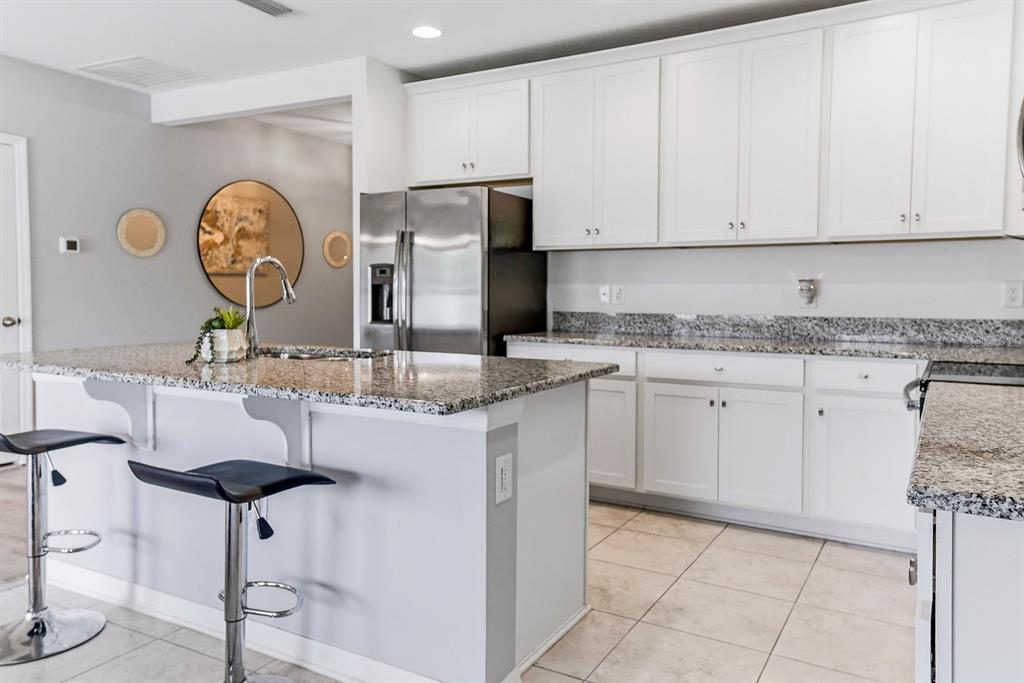 A bright entryway features light wood-look flooring, a white front door, and a console table — 12103 GOTHIC ROAD, SPRING HILL, FL