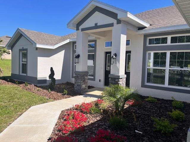 A single-story house with a white exterior and gray roof sits on a grassy lot — 37266 HIDDEN VIEW CIRCLE, DADE CITY, FL