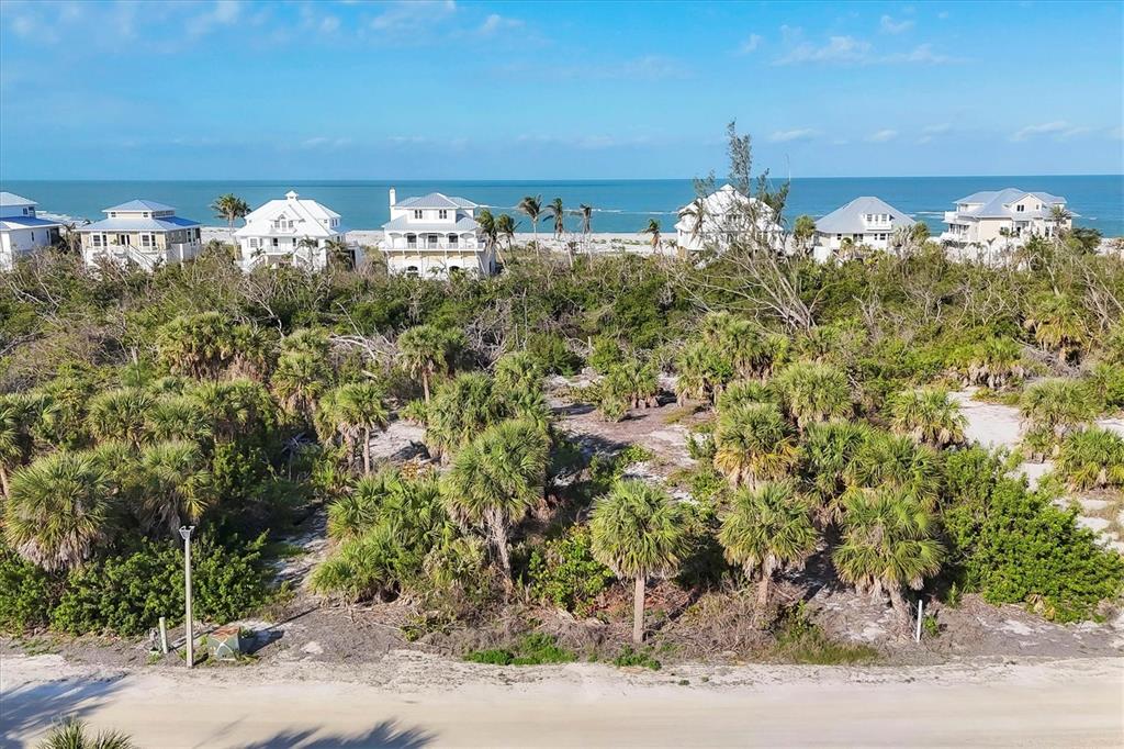 An aerial view shows a sandy lot with palm trees in front of beachfront houses — 6150 RUM COVE DRIVE, PLACIDA, FL