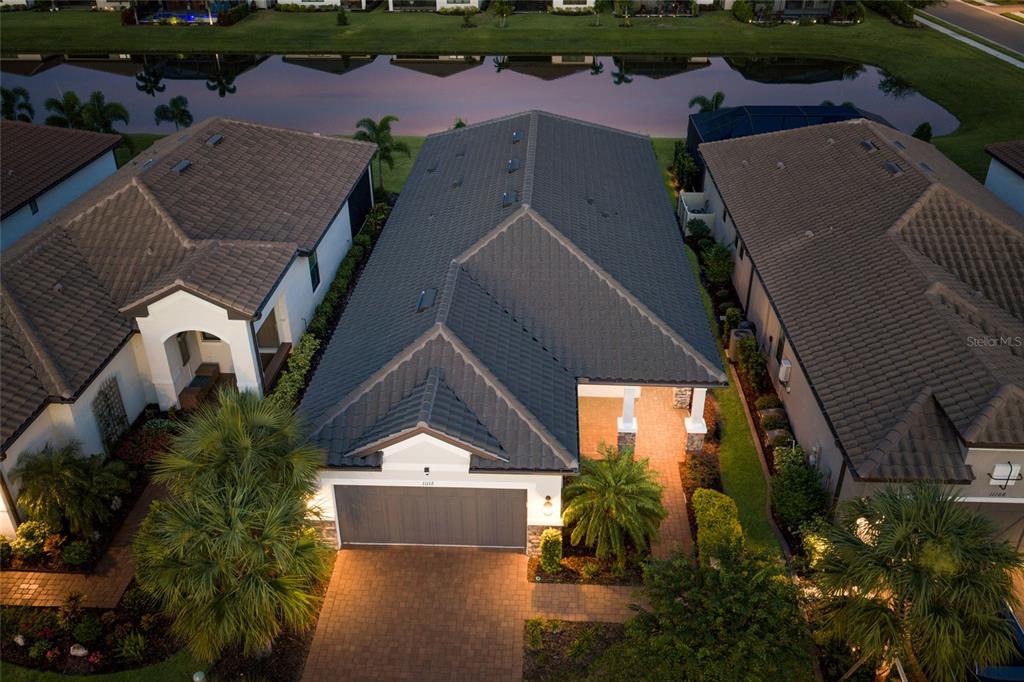 An aerial view of a single-story house with a tiled roof and a paved driveway — 11112 DEVONBRIDGE DRIVE, PALMETTO, FL