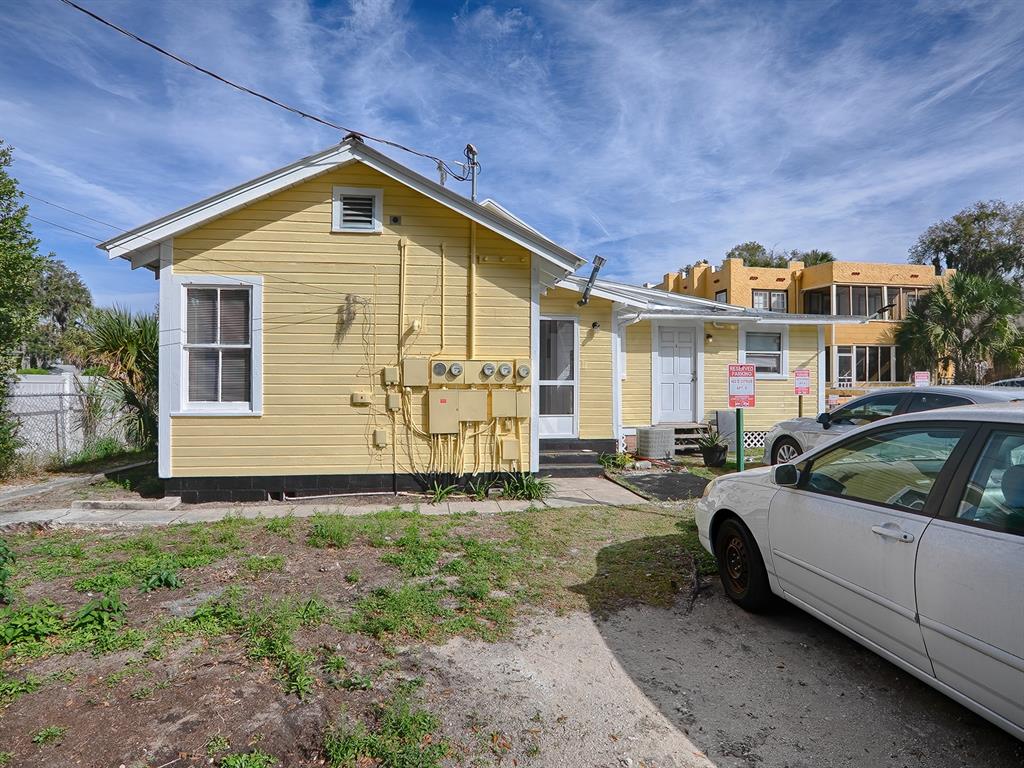 A yellow, single-story house with a white door and multiple electrical meters on the exterior — 422 E CITRUS AVENUE, EUSTIS, FL