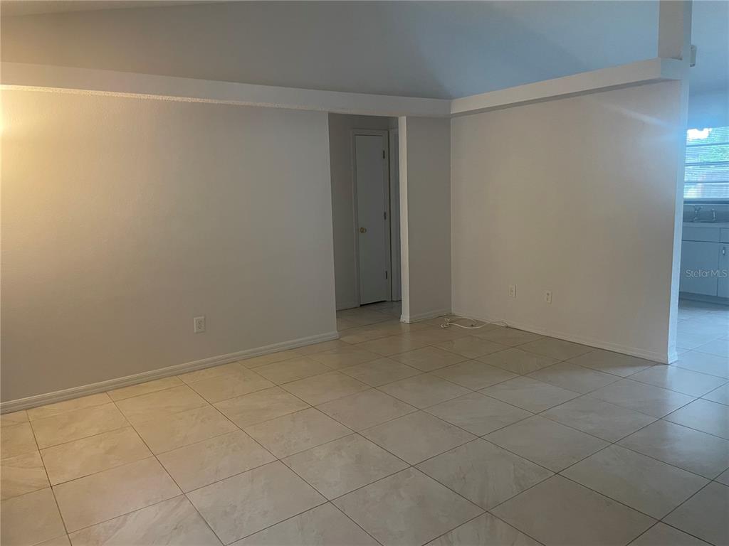 An interior view of a room with light-colored tile flooring and white walls — 1349 PIERCE STREET, CLEARWATER, FL