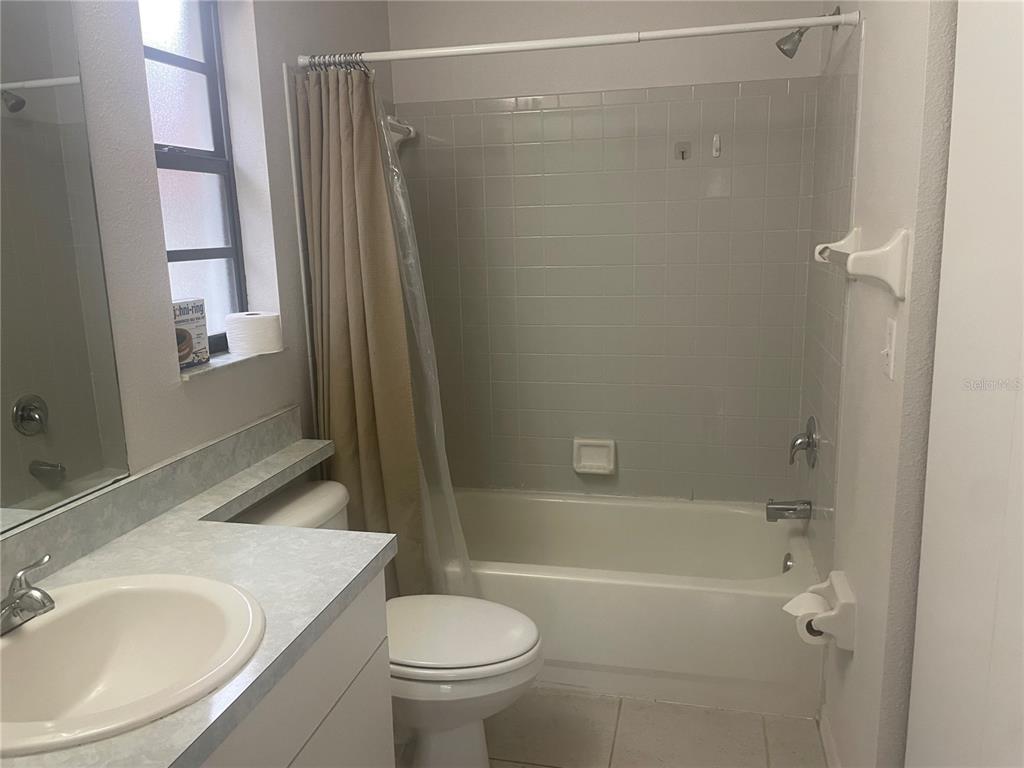 A bathroom features a vanity with a sink, a toilet, and a tub-shower combination — 1349 PIERCE STREET, CLEARWATER, FL