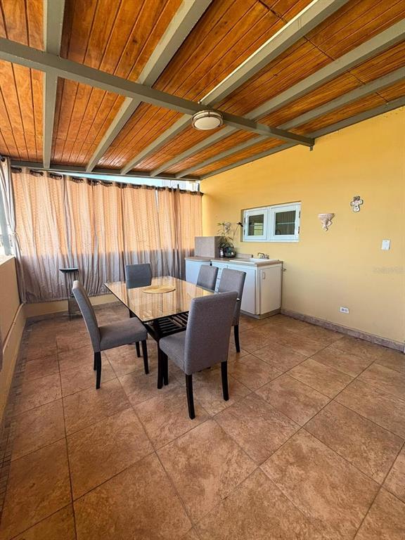 A covered outdoor dining area features a glass table, four chairs, and a small kitchenette — 520 RIERA UNIT 3, SAN JUAN, PR