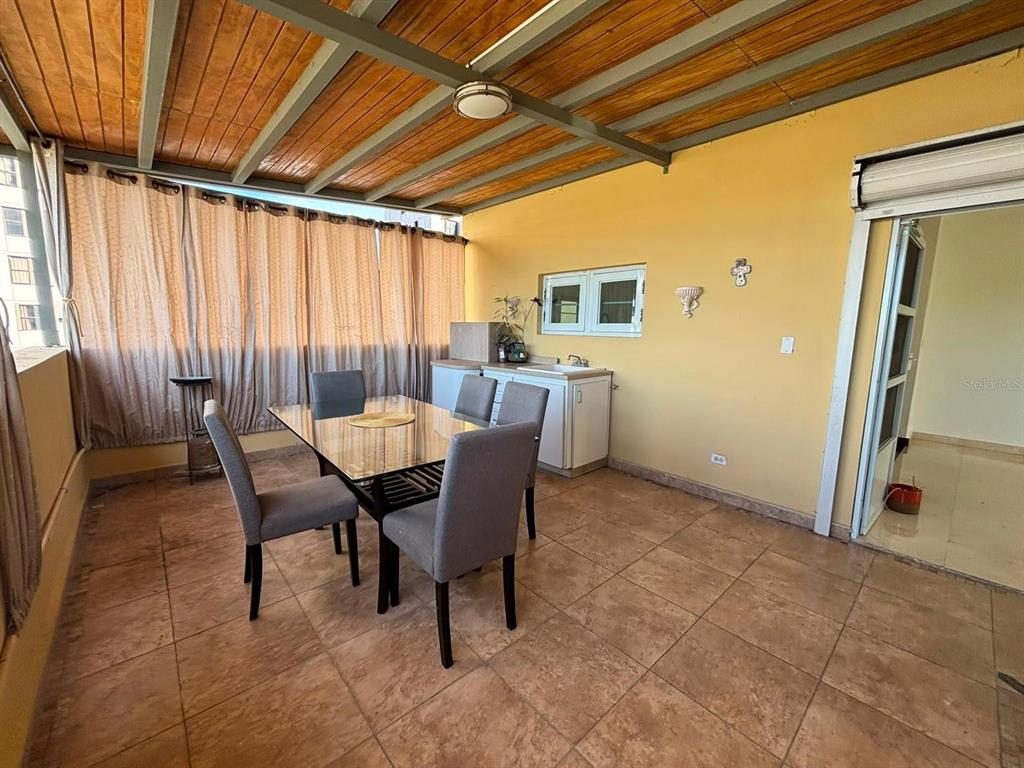 A covered patio features a glass dining table, four chairs, and a small kitchenette area — 520 RIERA UNIT 3, SAN JUAN, PR