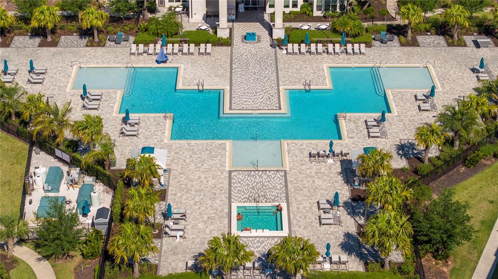 An aerial view of a resort-style swimming pool complex with lounge chairs and palm trees — 7770 SANDY RIDGE DRIVE UNIT 219, REUNION, FL
