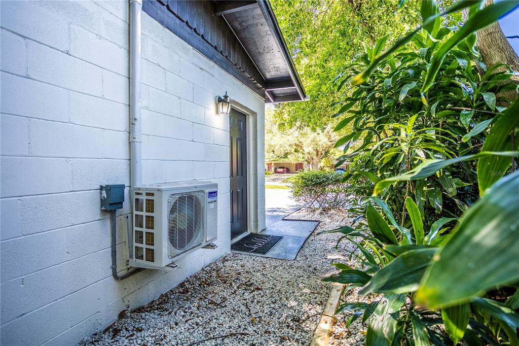 An exterior view shows a white concrete block wall, a door, and an air conditioning unit — 1213 CORBETT LANE UNIT 2, ORLANDO, FL