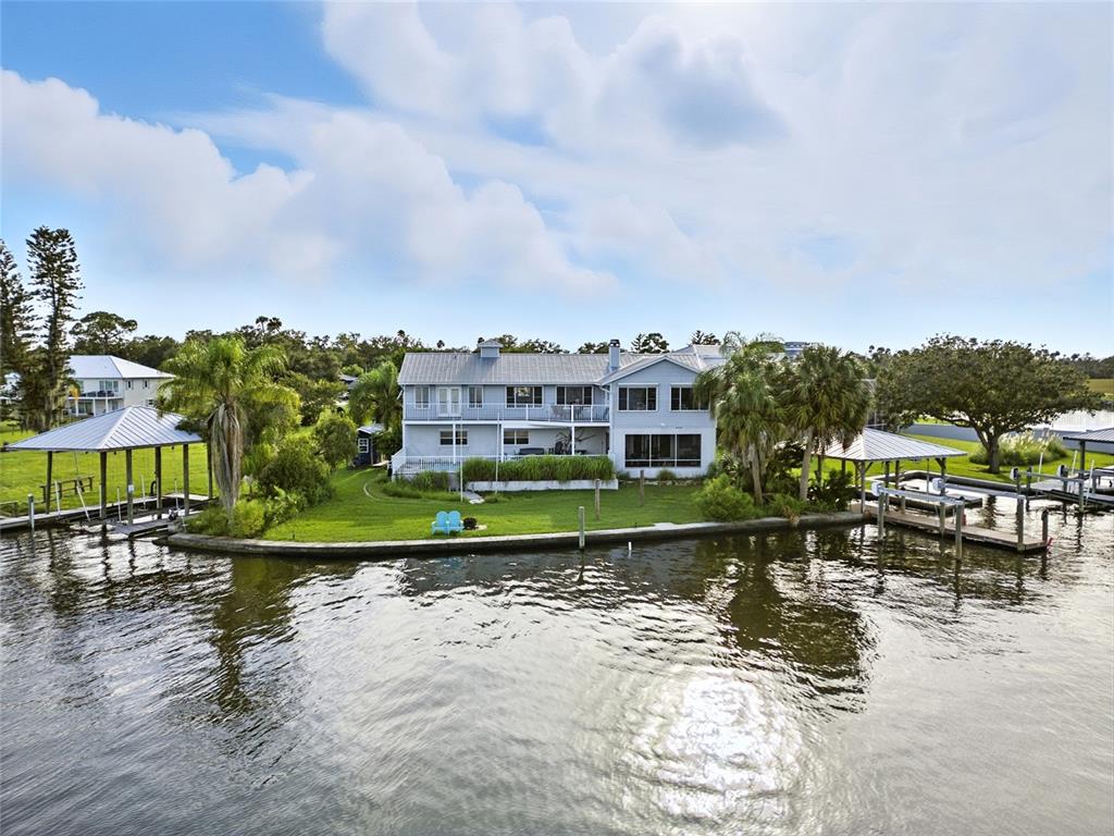 An aerial view of a two-story waterfront house with two boat docks and a lawn — 2435 N WATERSEDGE DRIVE, CRYSTAL RIVER, FL