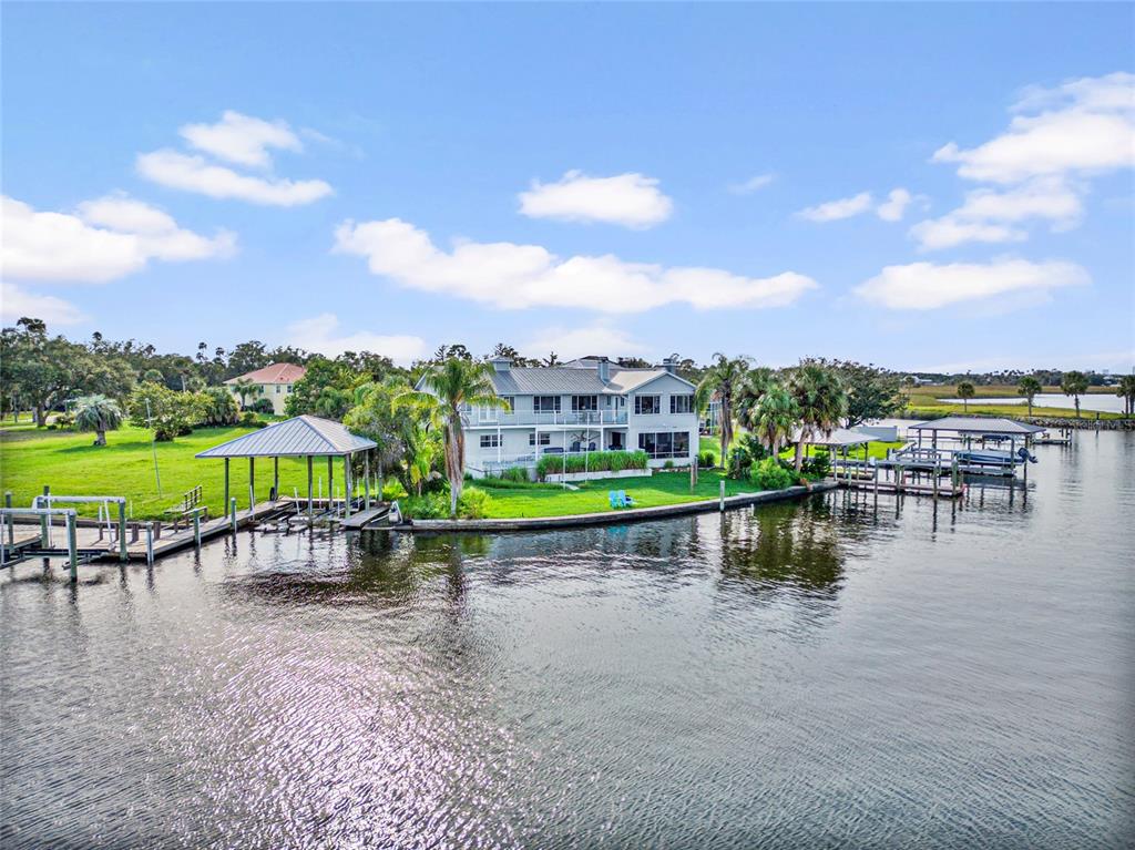 A waterfront house with a boat dock and pier sits on a grassy lawn — 2435 N WATERSEDGE DRIVE, CRYSTAL RIVER, FL