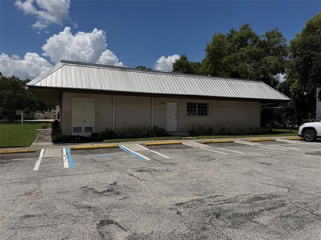 A single-story brick commercial building with a metal roof and an adjacent parking lot — 399 AVENUE K SE, WINTER HAVEN, FL