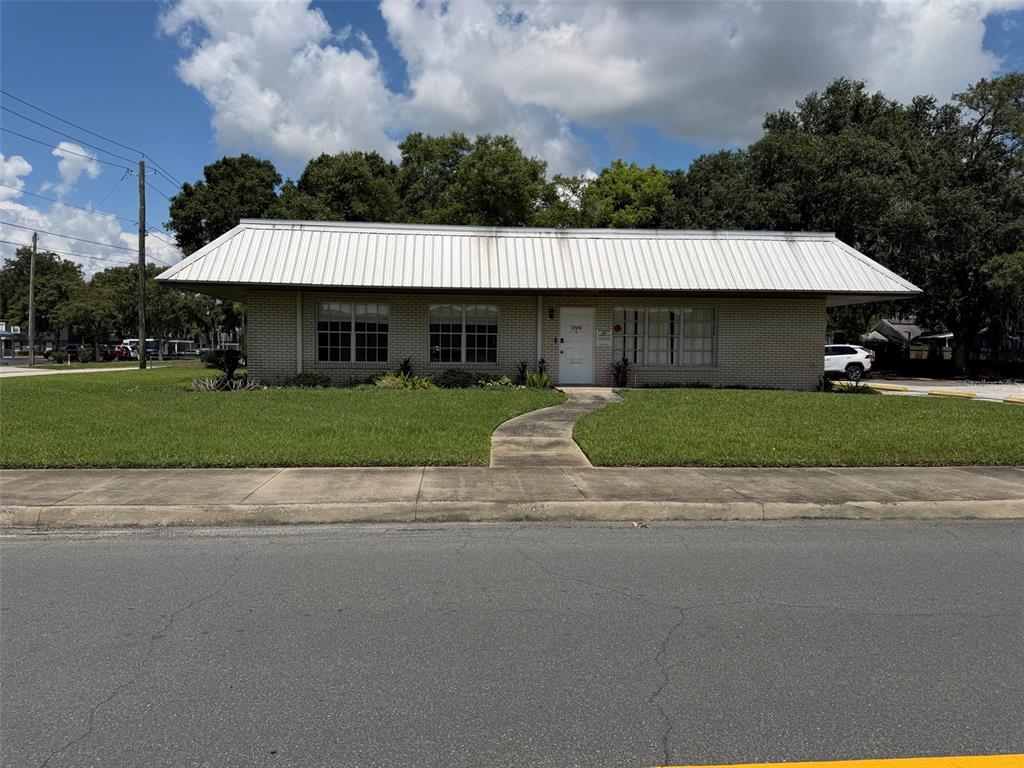 A single-story brick commercial building features a wide metal roof and a front walkway — 399 AVENUE K SE, WINTER HAVEN, FL