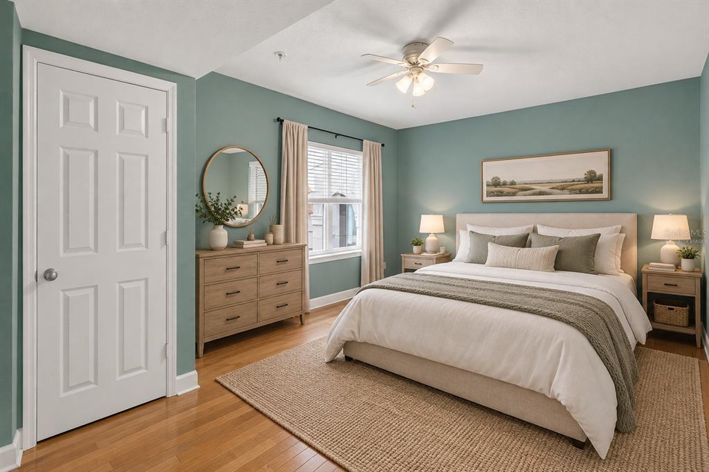 An open-concept living area with hardwood floors, gray walls, and an adjacent kitchen breakfast bar — 300 E SOUTH STREET UNIT 2014, ORLANDO, FL