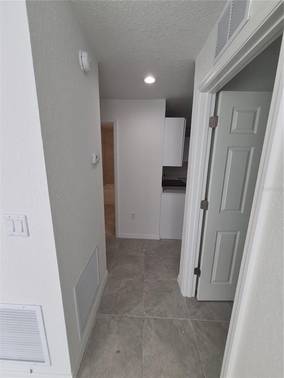 A kitchen features white cabinets, light countertops, a stainless steel sink, and tile flooring — 6 S BARBOUR STREET, BEVERLY HILLS, FL