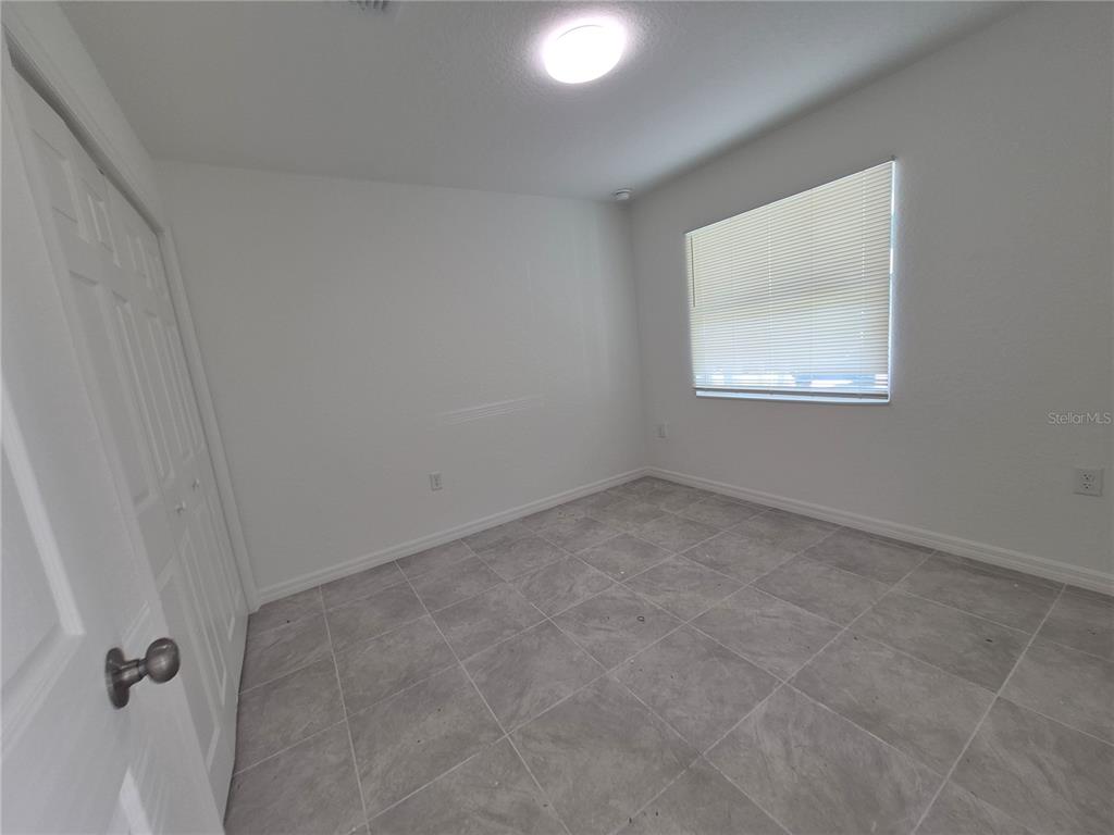 A bathroom features a white bathtub with light-colored, horizontal rectangular wall tiles — 6 S BARBOUR STREET, BEVERLY HILLS, FL