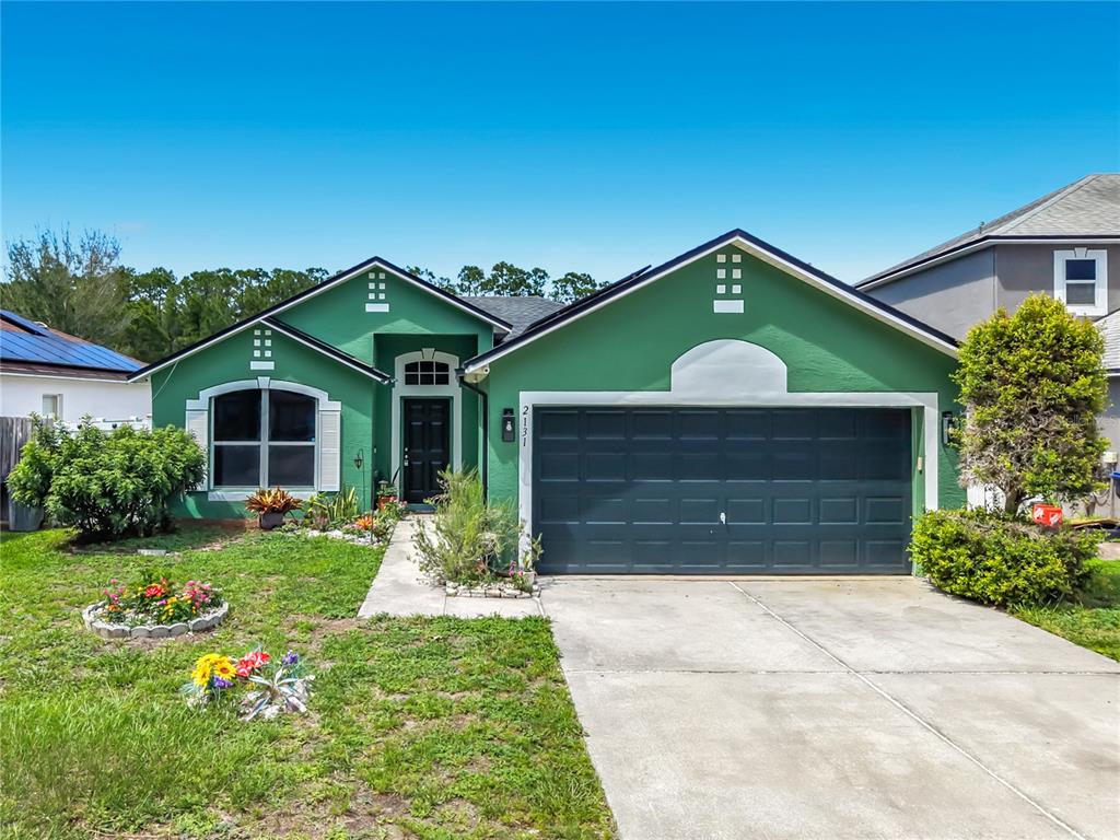 A green house exterior features a front door with a transom window and a walkway — 2131 CORNER SCHOOL DRIVE, ORLANDO, FL
