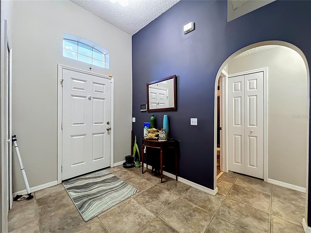 An entryway features tile flooring, a dark blue accent wall, and an arched doorway — 2131 CORNER SCHOOL DRIVE, ORLANDO, FL