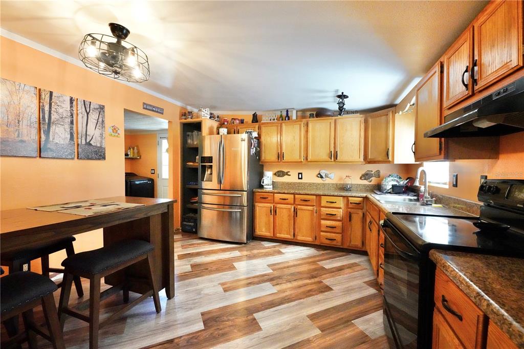 A kitchen with wood cabinets, stainless steel appliances, and a dining table with two chairs — 7494 GORDON LOOP, BROOKSVILLE, FL