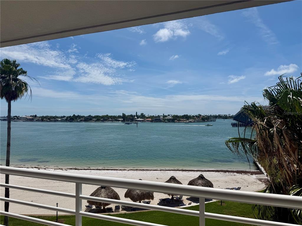 A balcony view overlooks a sandy beach, palm trees, and a body of water — 5701 BAHIA DEL MAR CIRCLE UNIT 407, ST PETERSBURG, FL