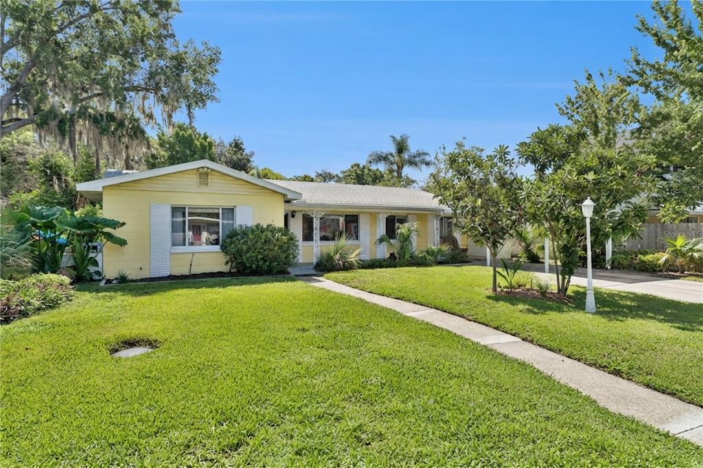 A yellow single-story house with a front lawn and a concrete walkway — 1003 LAKE BELL DRIVE, WINTER PARK, FL