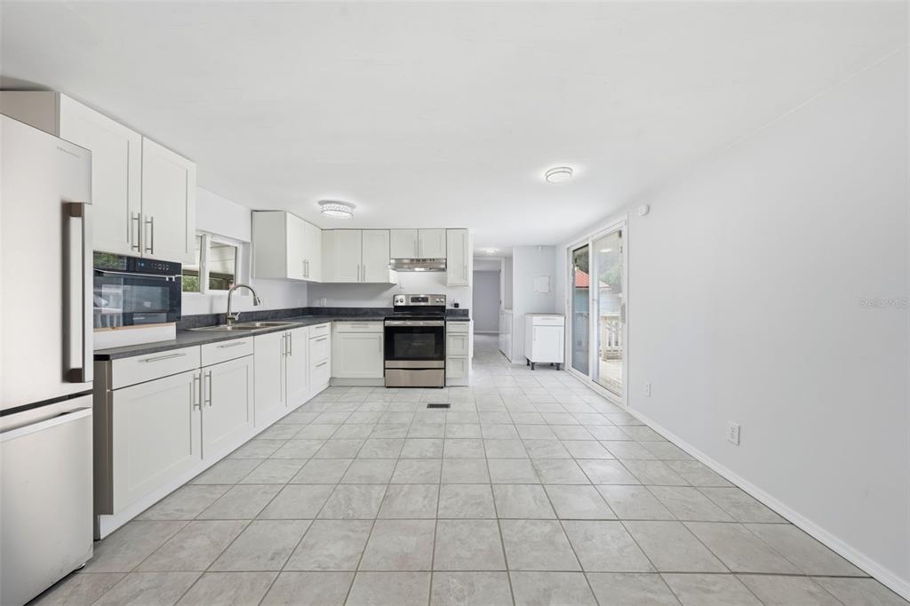 A kitchen with white cabinets, stainless steel appliances, and light-colored tile flooring — 44945 2ND STREET, DELAND, FL