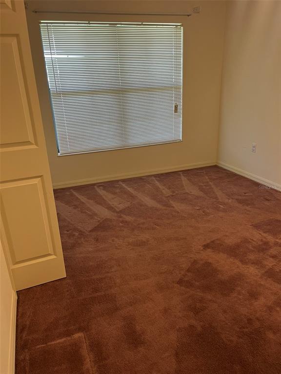 A closet with a wire shelf and white bifold doors sits in a carpeted room — 8451 SW 14TH LANE, OKEECHOBEE, FL