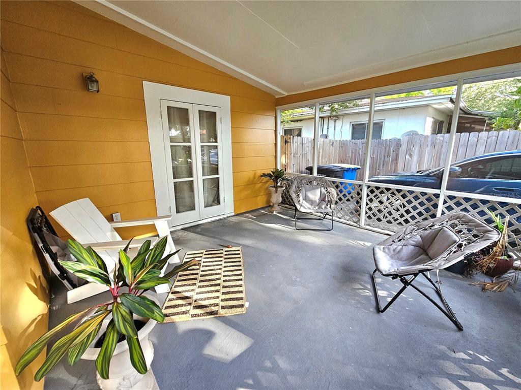 A screened-in porch with yellow walls, a concrete floor, and several pieces of patio furniture — 1500 N OSCEOLA AVENUE, CLEARWATER, FL