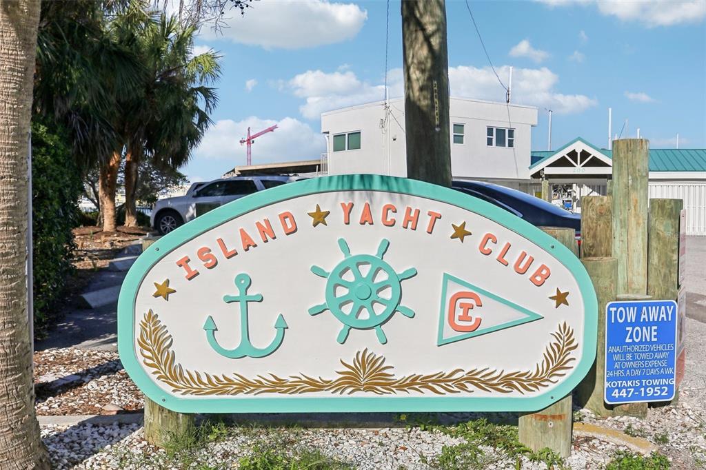 A sign for the Island Yacht Club stands in a parking area near a building — 200 WINDWARD PASSAGE UNIT 84, CLEARWATER, FL